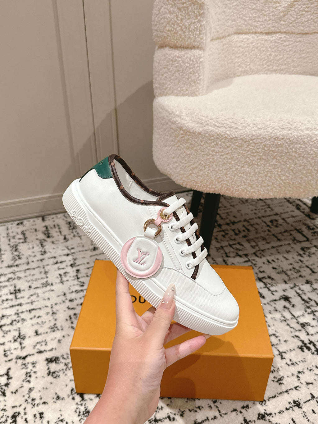 White leather low-top sneakers with green collar lining and small emblem