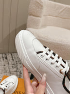 White leather sneakers side view with white laces and textured rubber sole