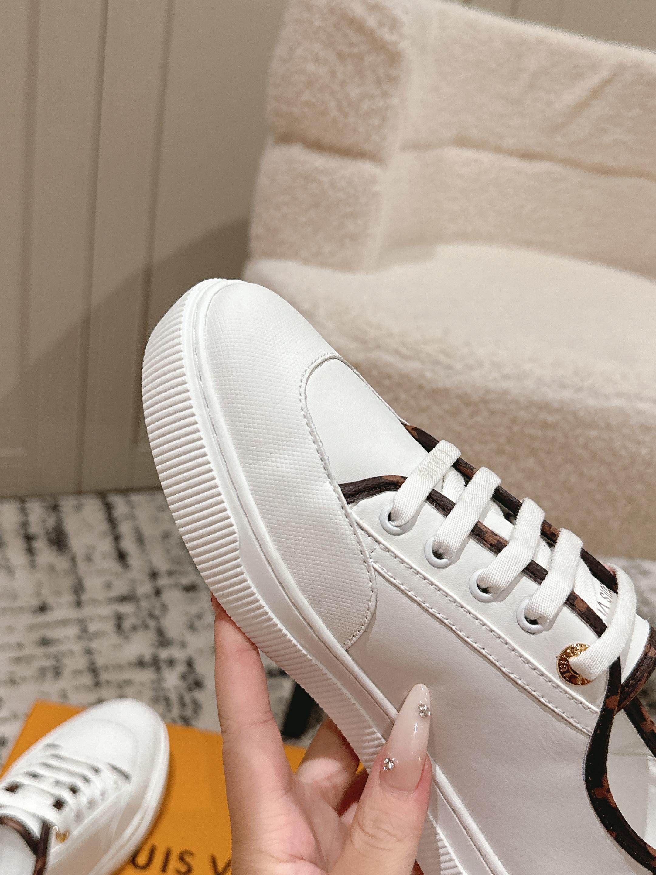 White leather sneakers side view with white laces and textured rubber sole