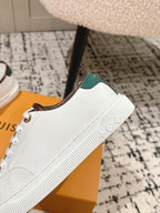 White leather sneakers with side laces and green interior collar trim