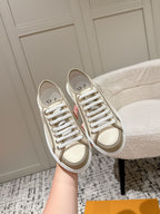 Pair of Louis Vuitton low-top sneakers in light beige with white laces and rubber sole