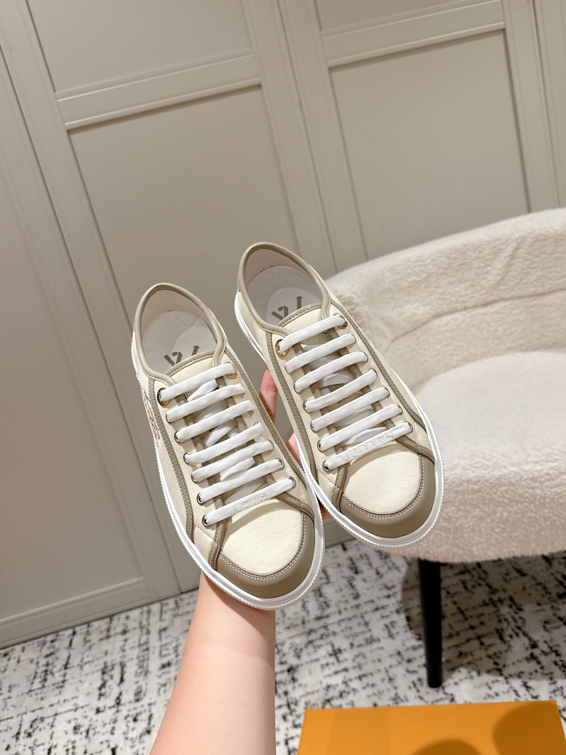 Cream low-top sneakers with white laces, rubber sole, Louis Vuitton logo