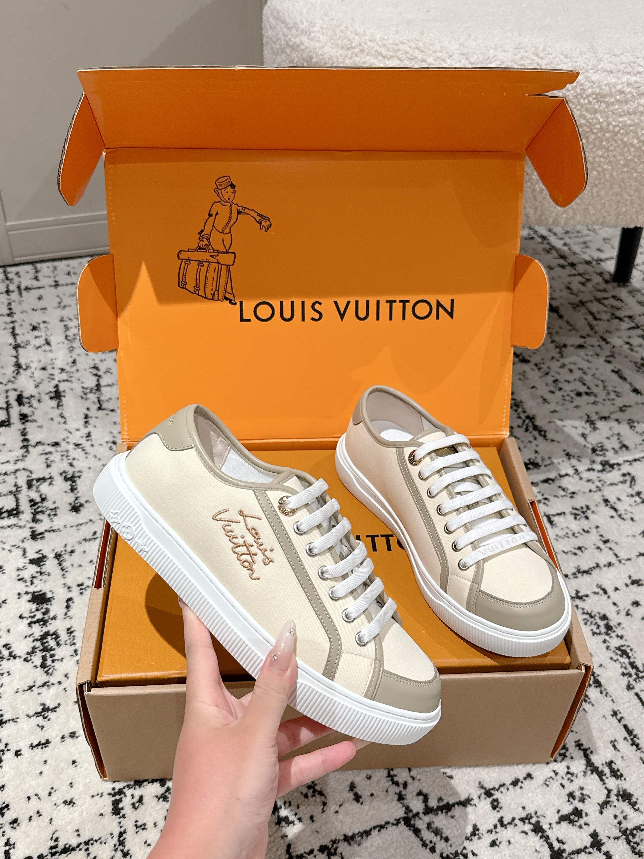 Pair of light beige Louis Vuitton sneakers with white laces and side logo detail