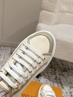 Louis Vuitton low-top sneaker close-up with white laces on light beige canvas upper
