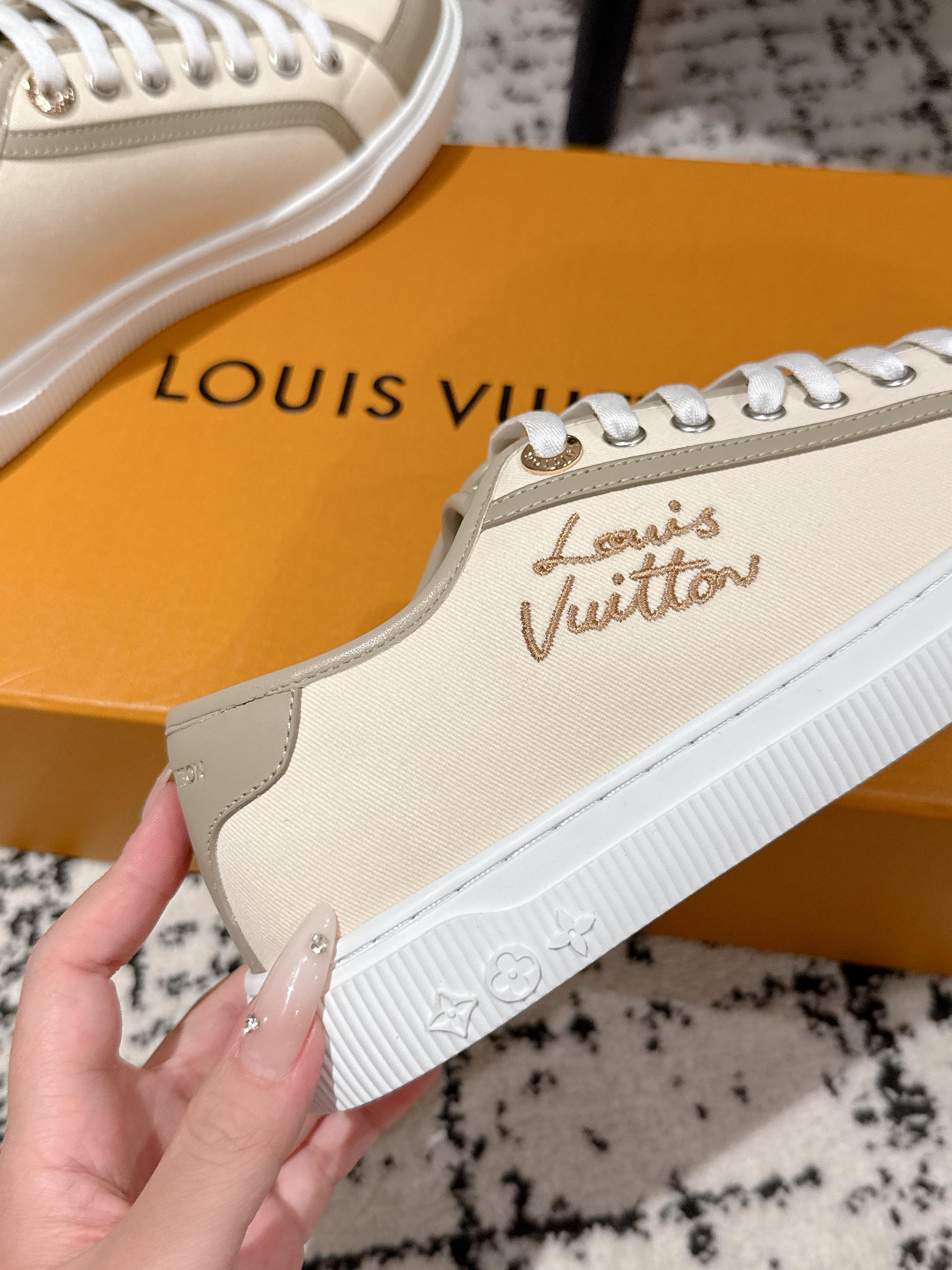 Cream sneaker side close-up with Louis Vuitton embossed logo and white laces