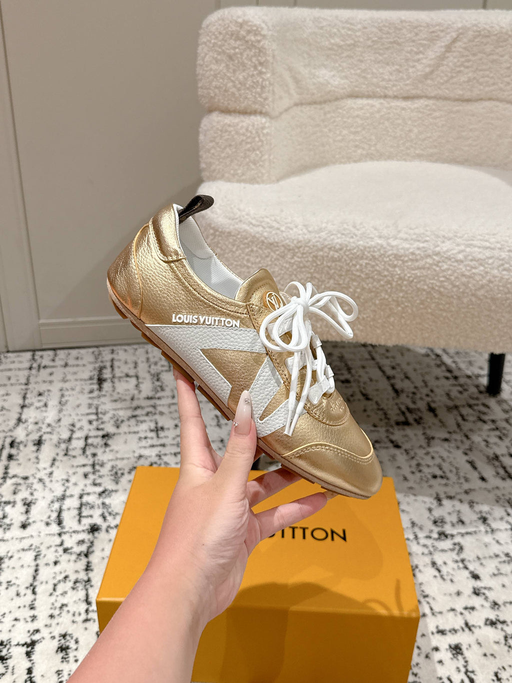 Gold and white leather low-top sneakers with white laces, brand logo on tongue.