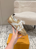 Gold and white leather low-top sneakers with white laces, brand logo on tongue.