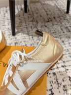 Gold and white leather sneaker with white laces, side profile on shoebox.