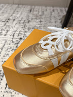 Gold leather sneaker with white laces and white paneling, close-up on shoebox.