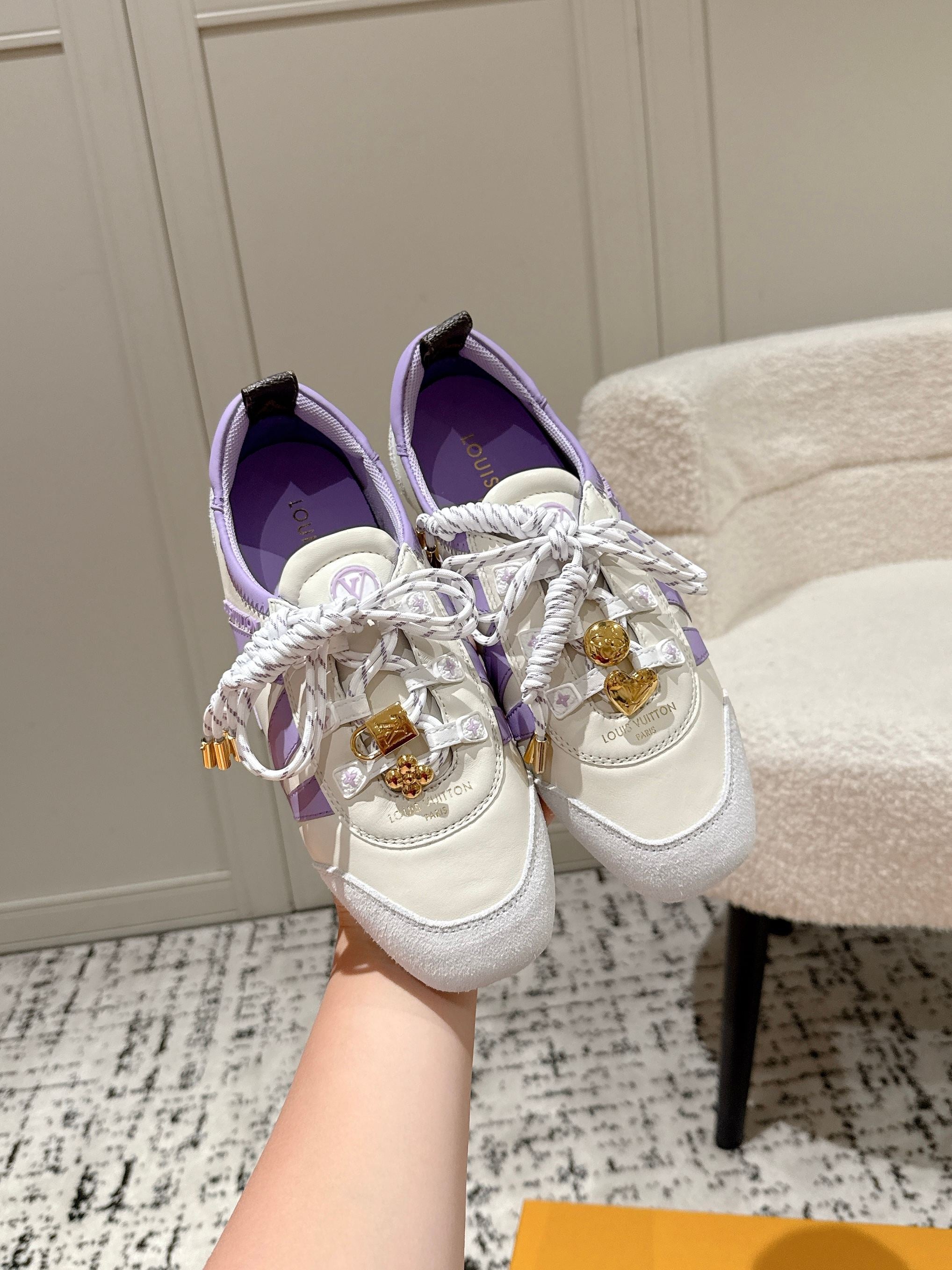 Louis Vuitton lace-up sneakers in white with lavender trim and gold emblem details