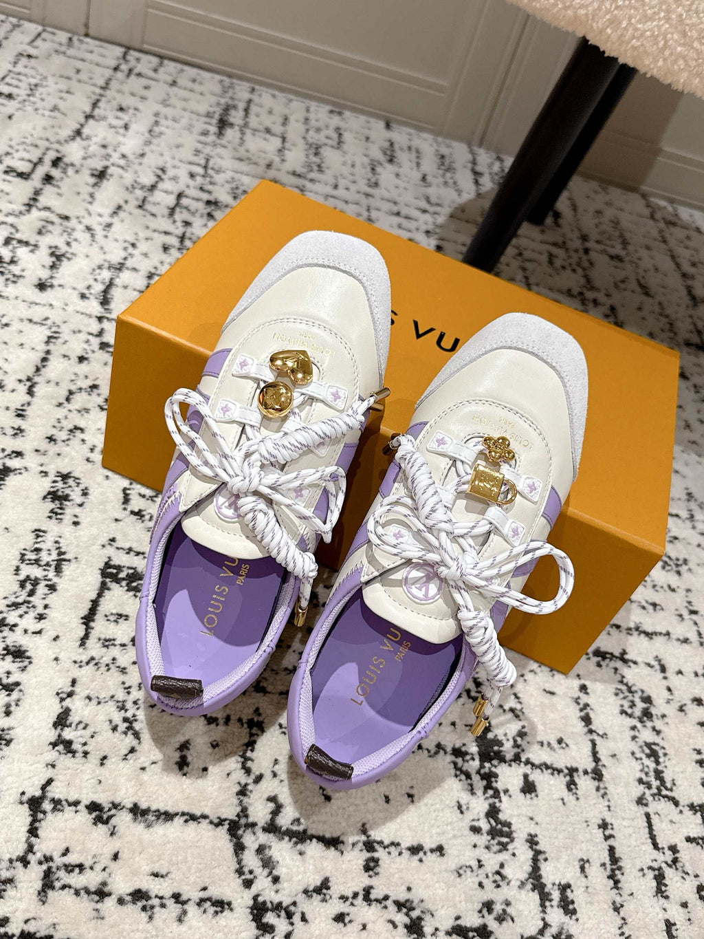 White and lavender Louis Vuitton sneakers with gold charm hardware, laced and matched pair