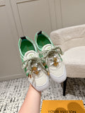 White sneakers with mint green panels, lace-up design and gold charm detail