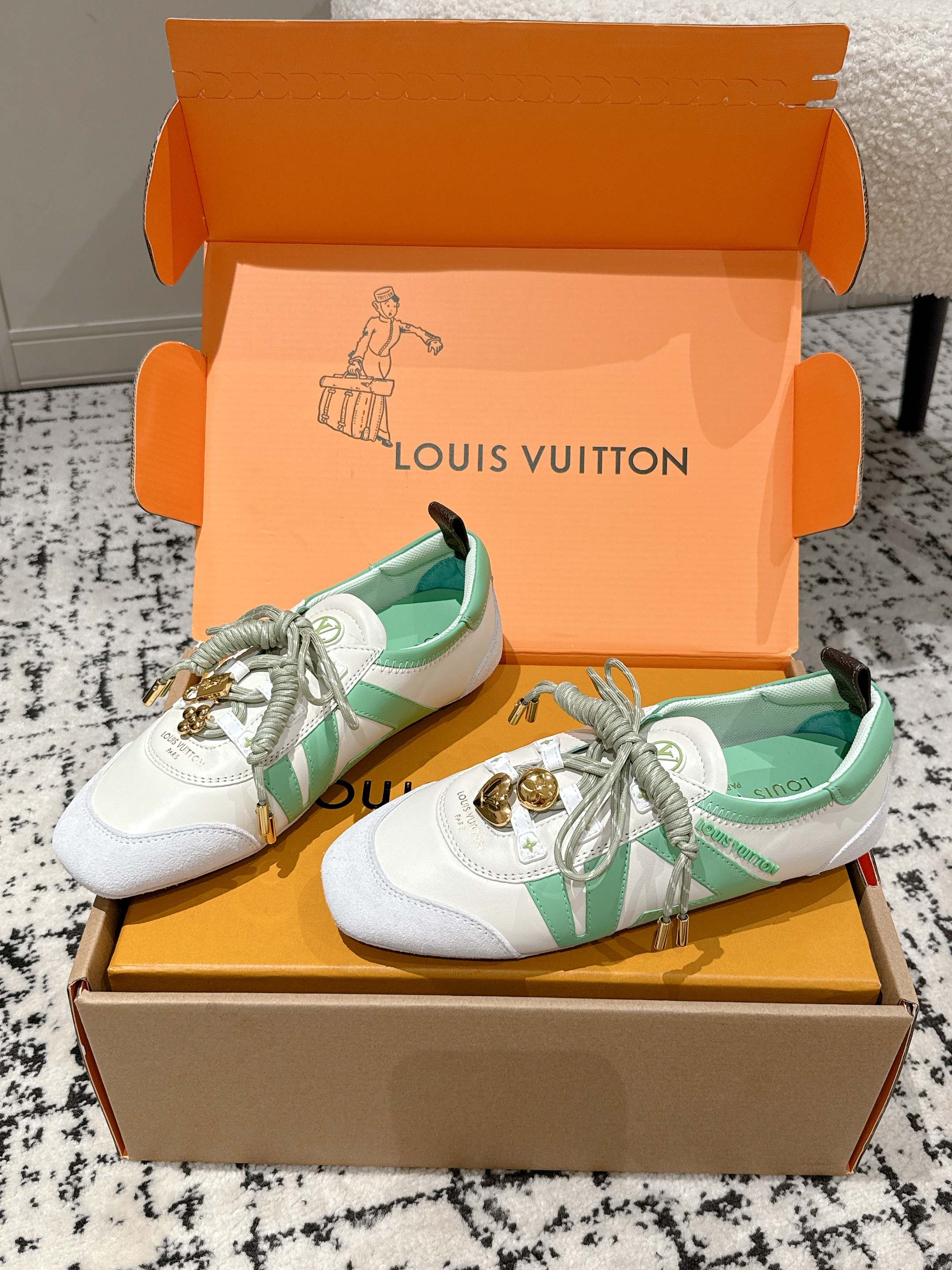 Unisex Louis Vuitton sneakers with mint green accents in open box, tied white laces