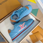Light blue Louis Vuitton unisex sneakers with colorful LV emblem and red/blue stripe sole
