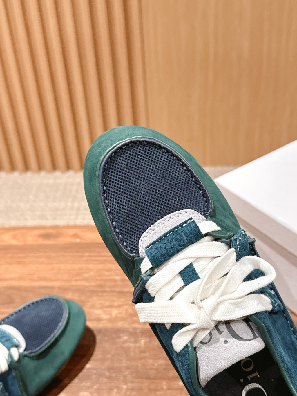 Teal low-top sneaker detail with mesh tongue panel, white laces, green collar
