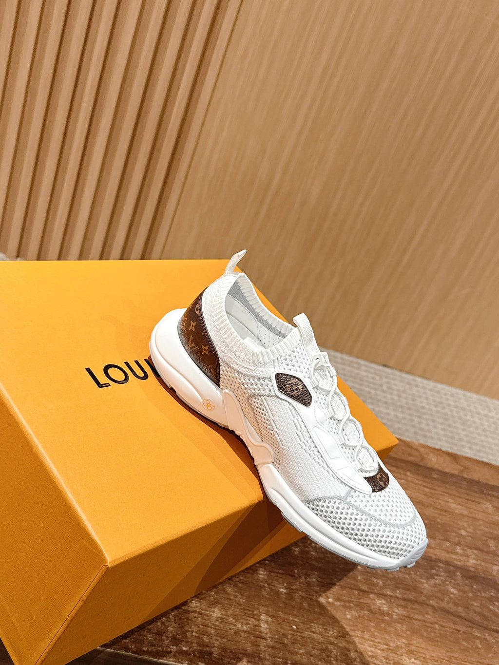 Louis Vuitton unisex white sneakers with lace-up design and brown monogram patch on upper