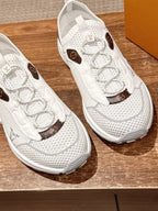 Louis Vuitton unisex white sneakers close-up showing lace eyelets and brown logo patches