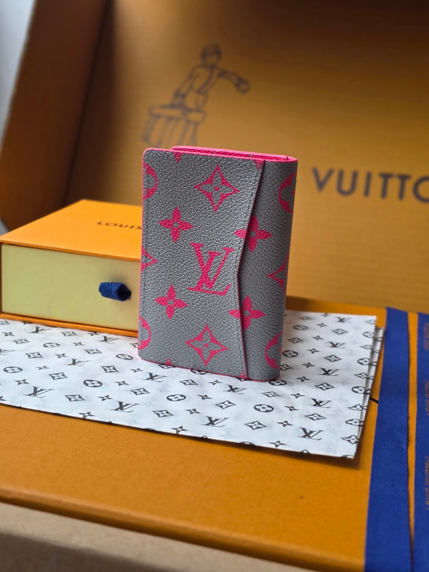 Small pink patterned card holder standing upright with fold-over front flap