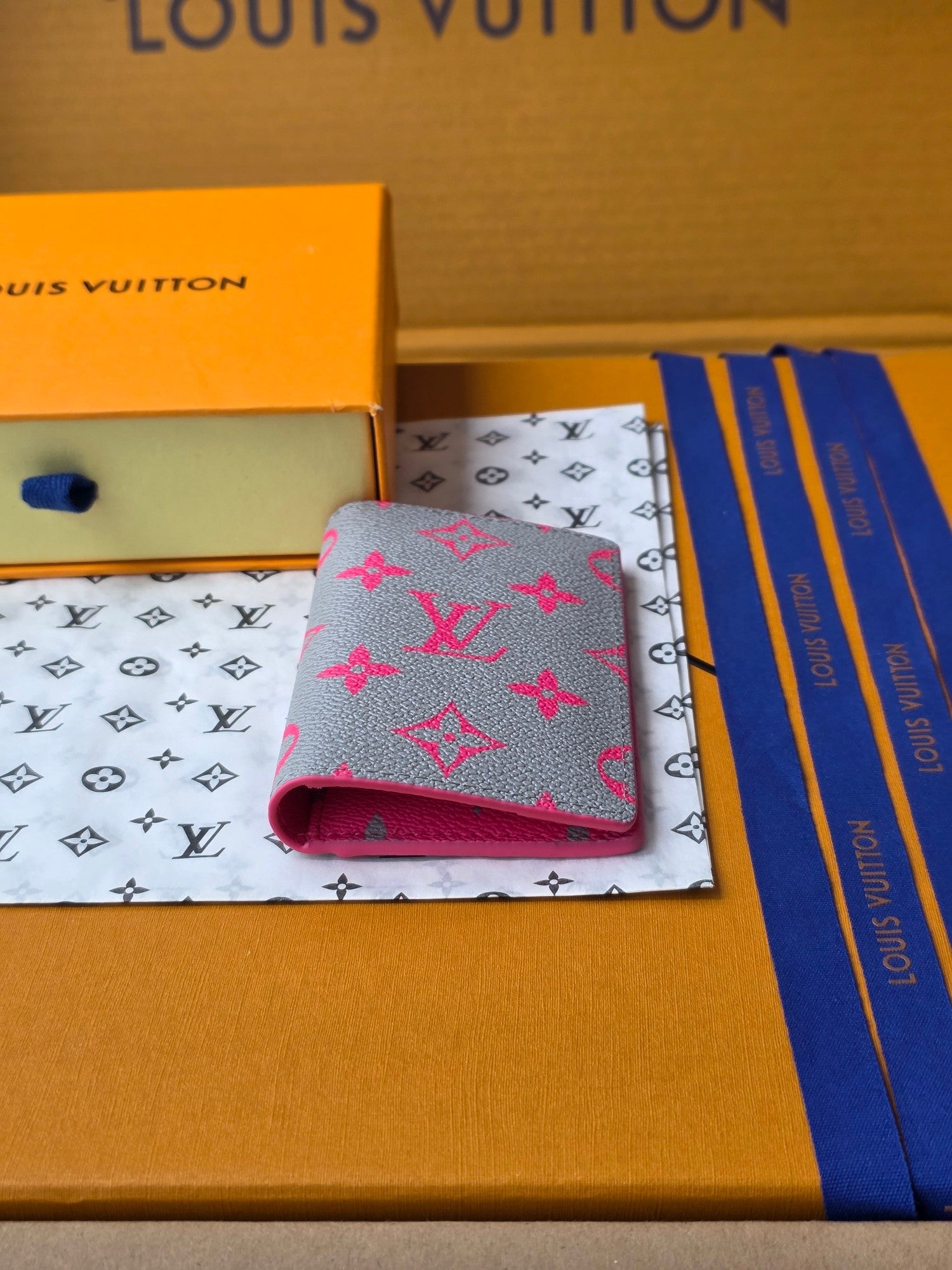 Small pink patterned card holder with fold-over flap, partially open to show inside