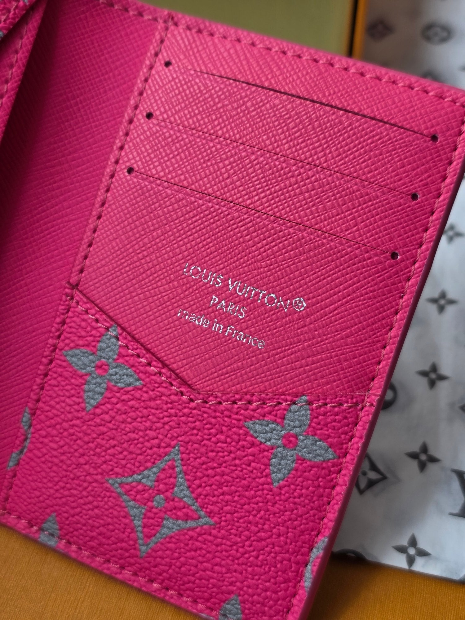 Small pink leather card holder close-up with Louis Vuitton Paris stamp and motifs