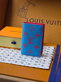 Small bag in bright blue with red monogram-style pattern and textured exterior