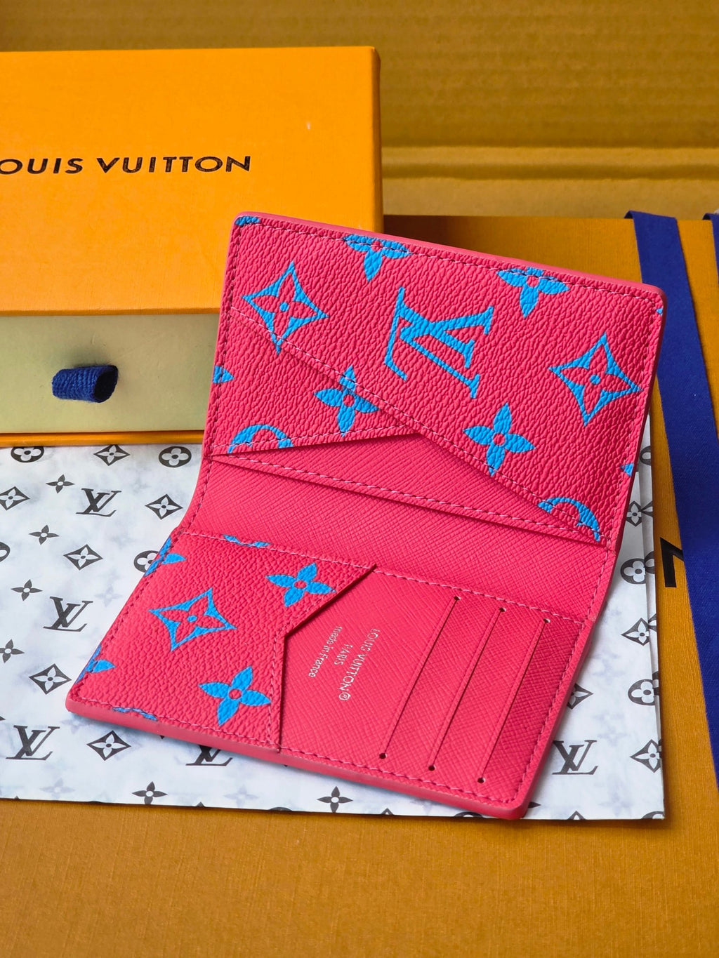 Small bag in pink with blue monogram-style pattern and front card-slot pocket