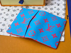Small bag in bright blue with red monogram-style pattern, laid flat