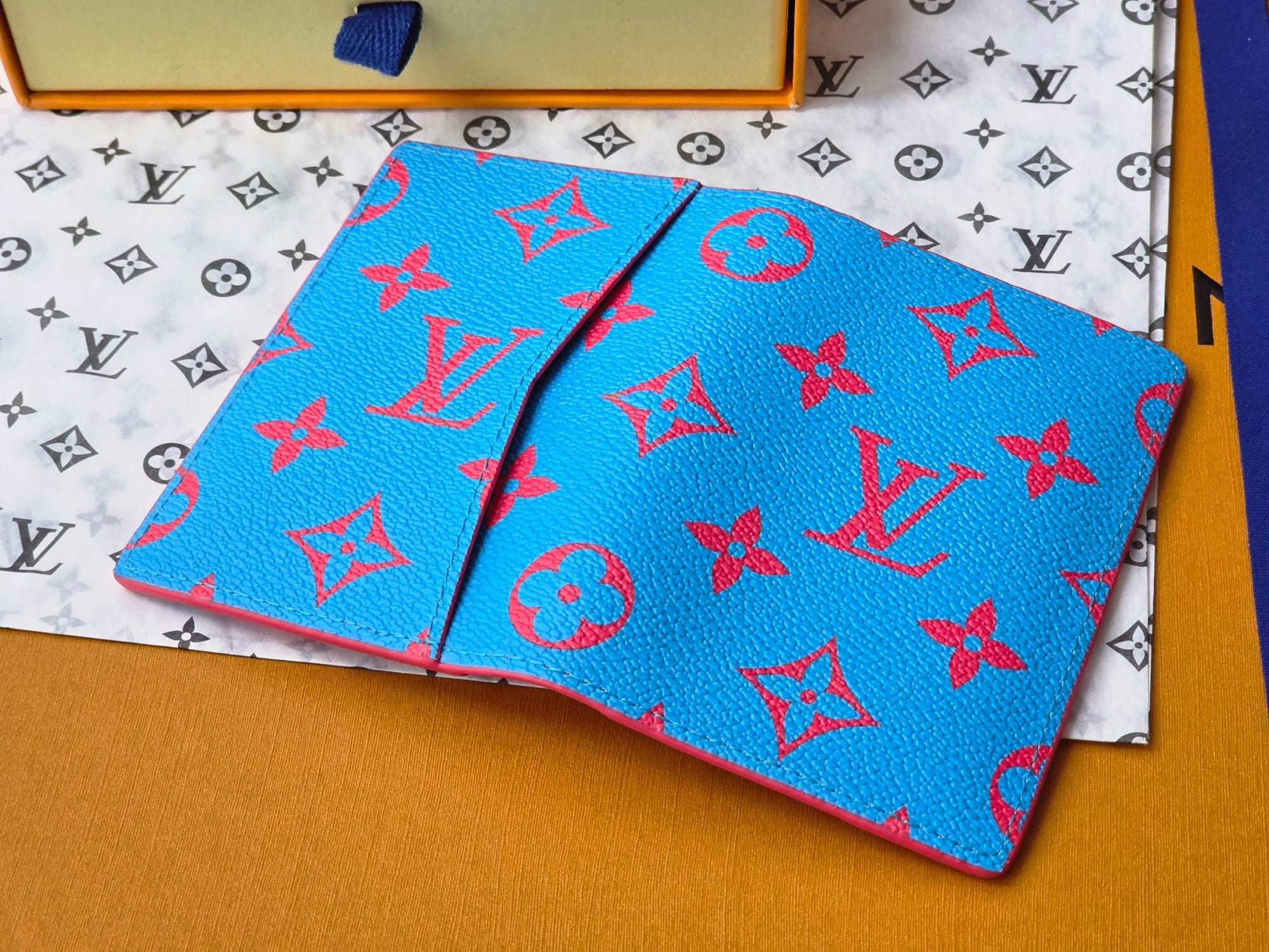 Small bag in bright blue with red monogram-style pattern, laid flat