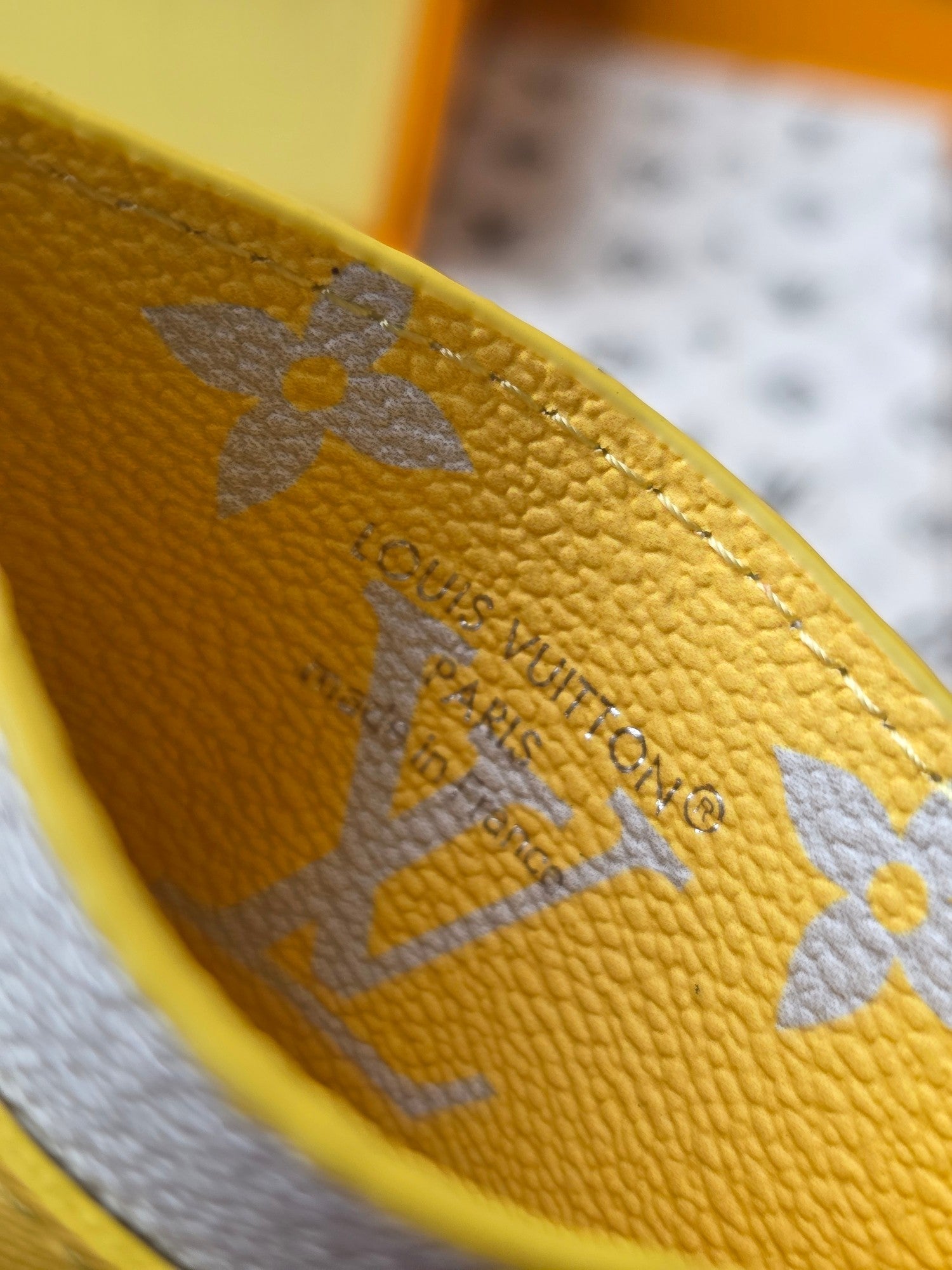 Louis Vuitton small bag close-up of textured monogram leather in light blue and gold tones