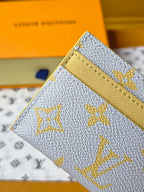 Louis Vuitton small bag close-up of top edge and yellow strap panel with blue monogram