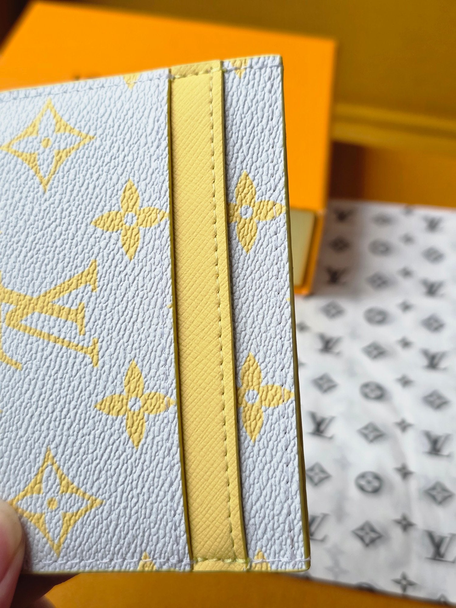Louis Vuitton small bag close-up of front panel with yellow stitched trim and monogram