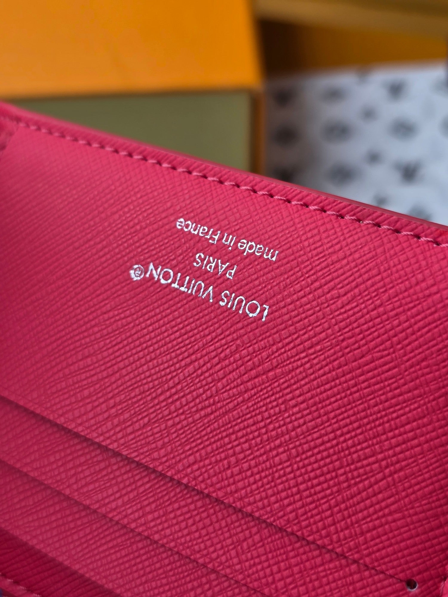 Small card wallet close-up of red leather with small printed text.