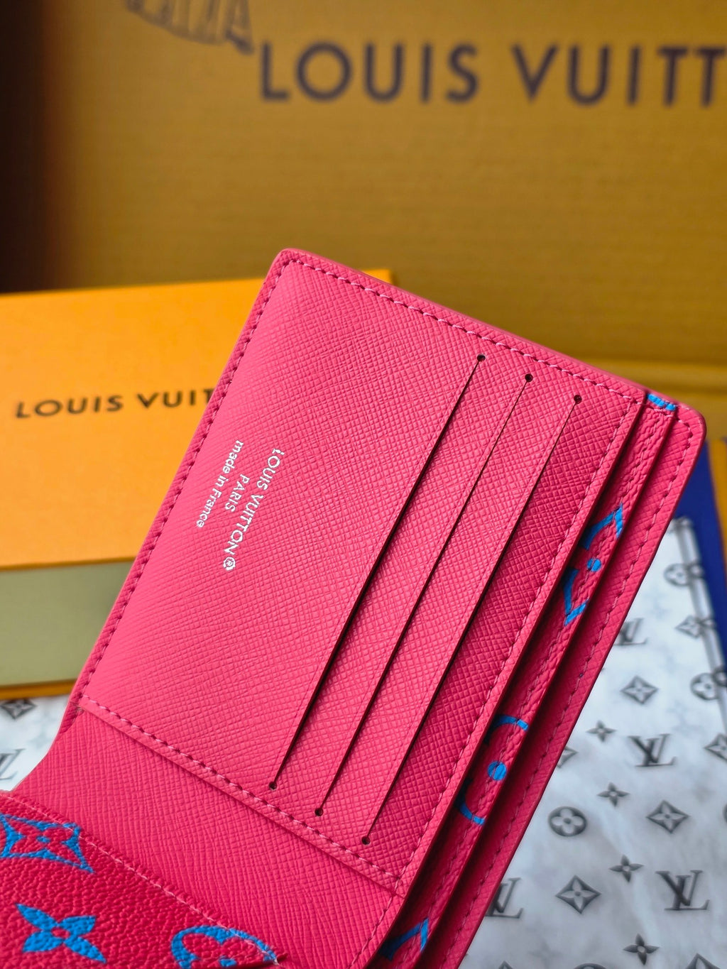Small card wallet open with several card slots and blue pattern on the flap.