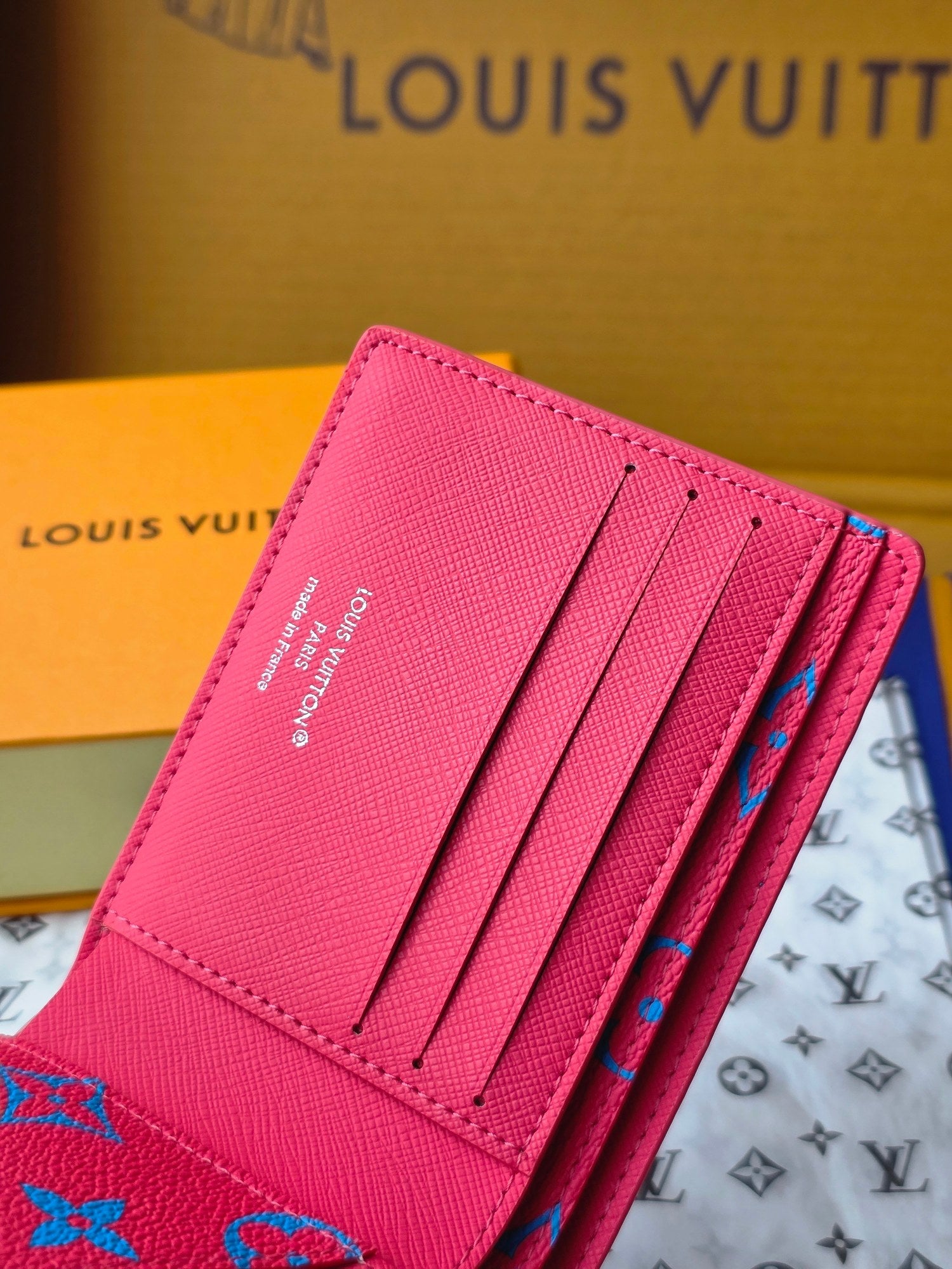Small card wallet open with several card slots and blue pattern on the flap.