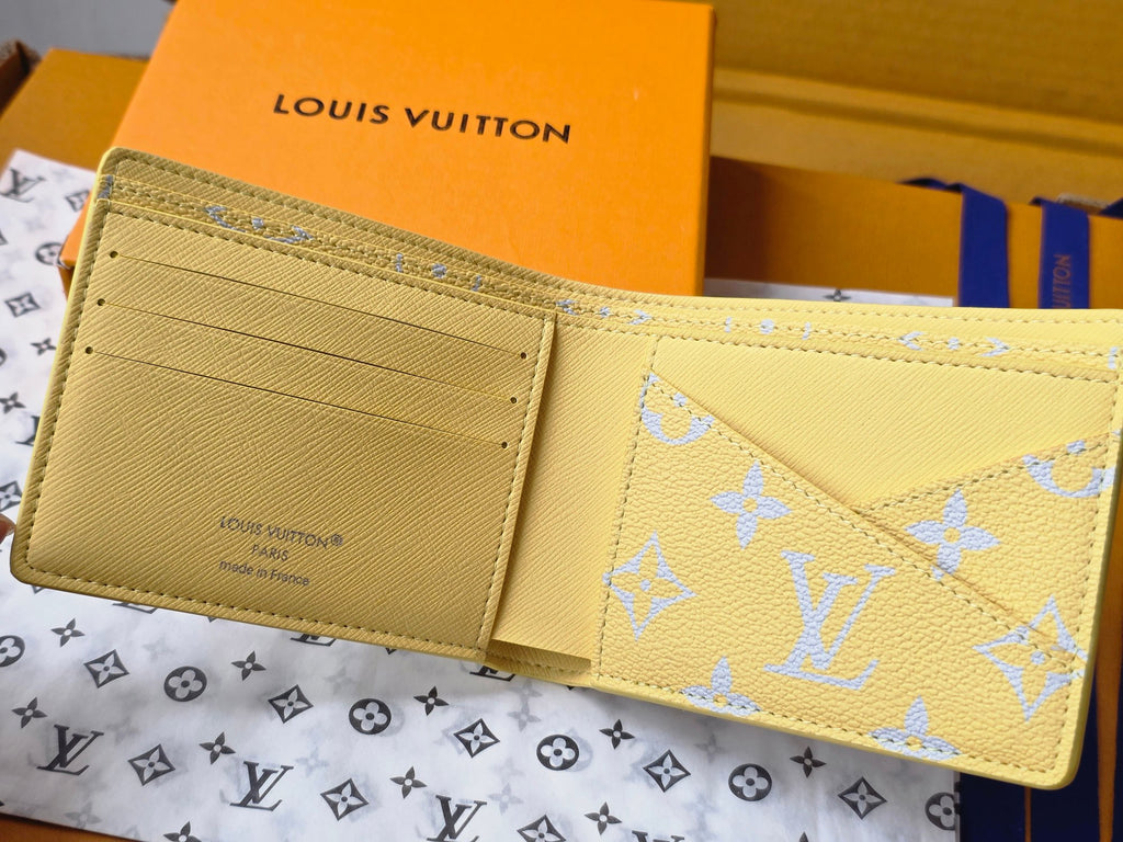 Small card wallet open, beige interior with gold monogram on blue exterior