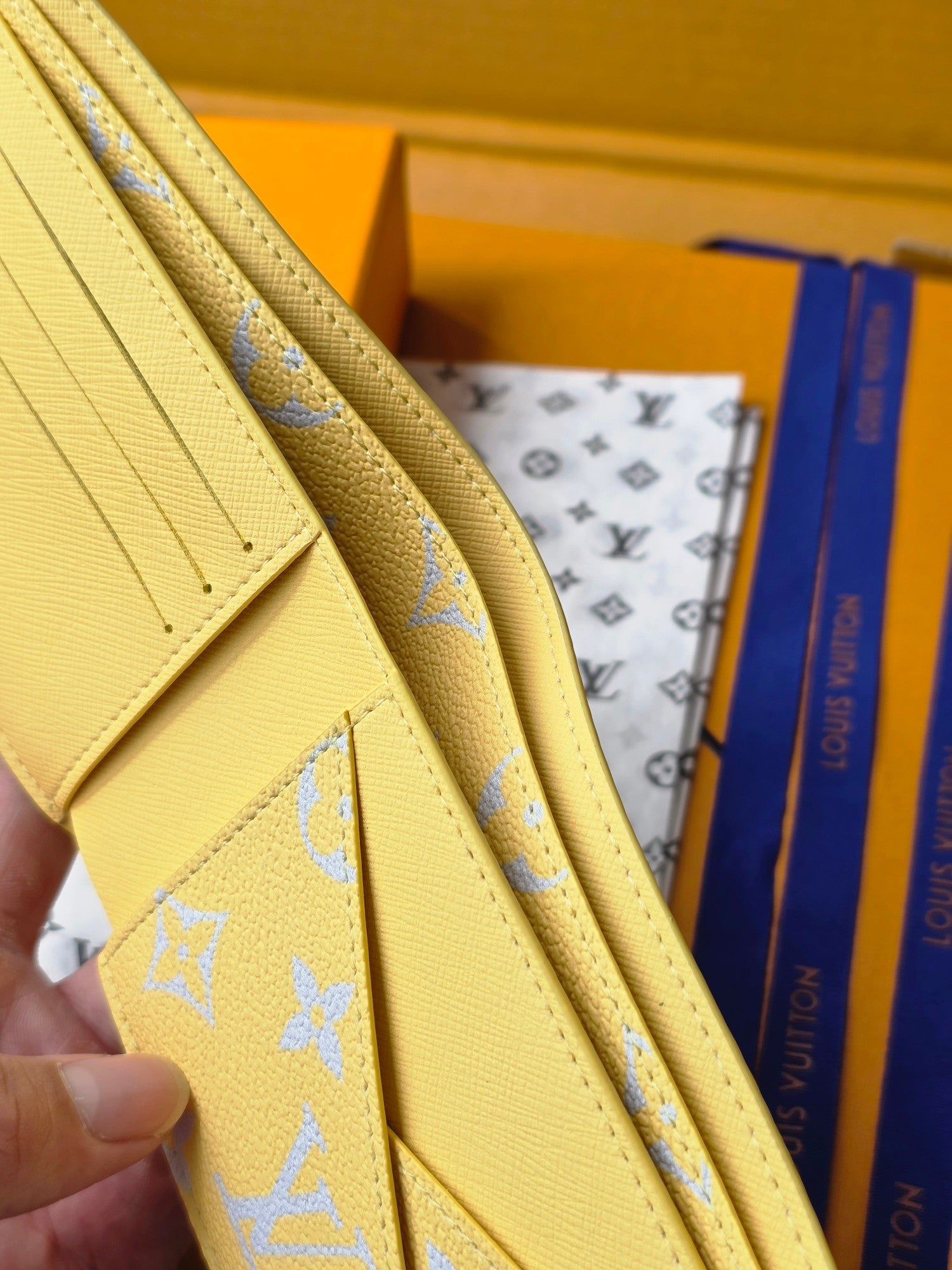 Small card wallet side view, layered card slots and blue monogram accents