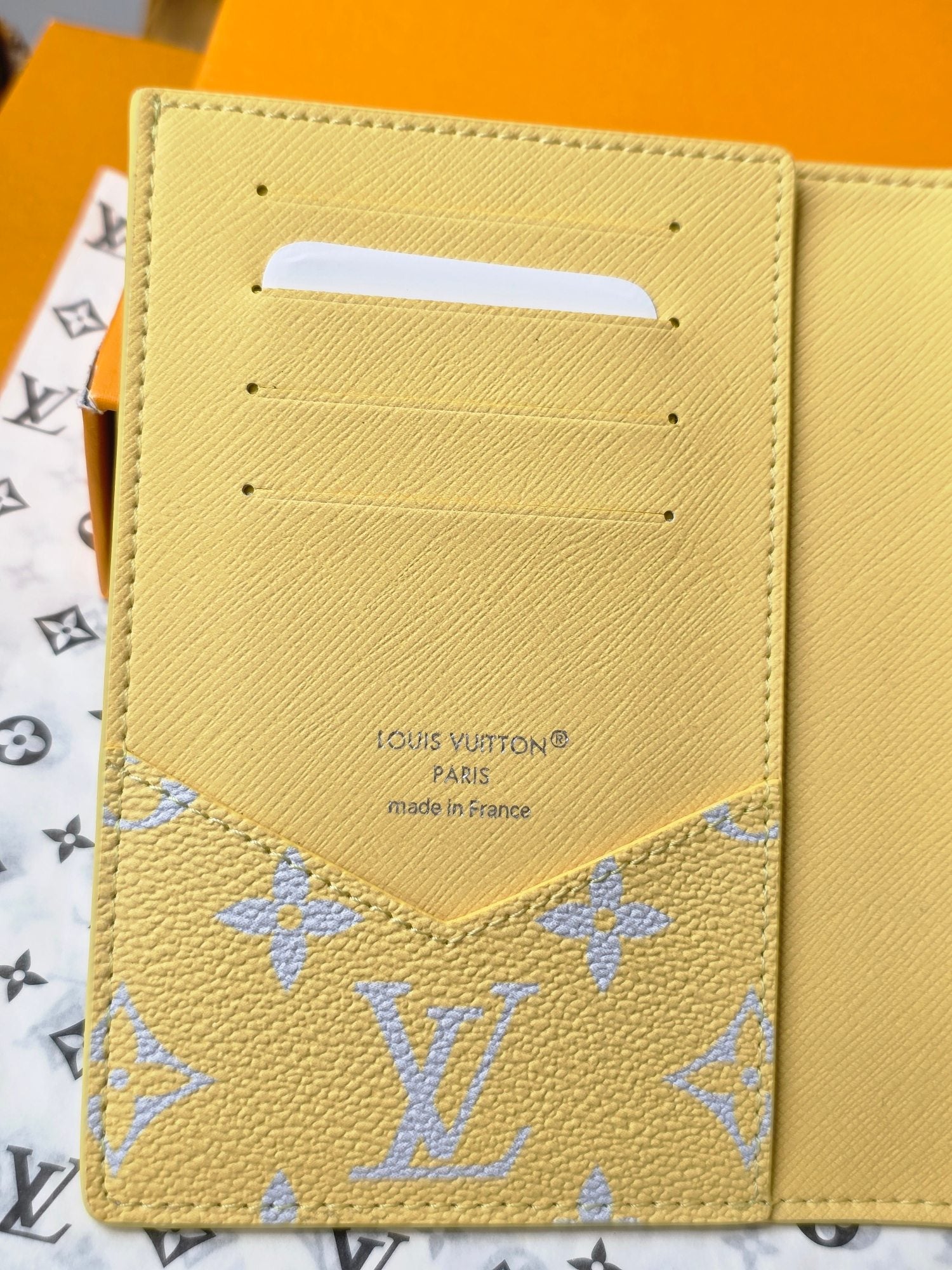 Small bag: Louis Vuitton yellow card case with blue monogram trim, front close-up