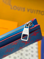 Small bag close-up of metal zipper pull and key ring, blue monogram side panel