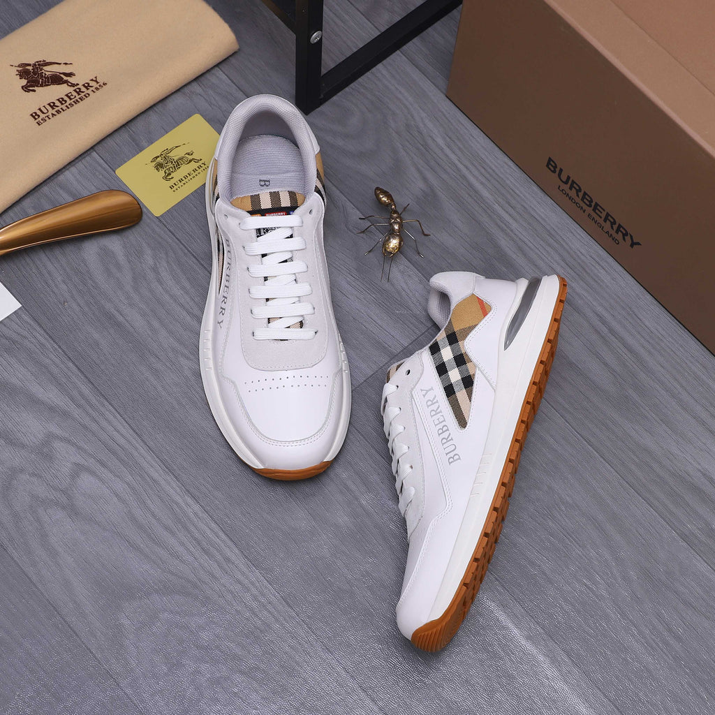 Pair of white Burberry low-top sneakers with plaid side accents and gum sole