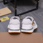 Pair of white Burberry sneakers showing heel tabs and gum rubber outsole