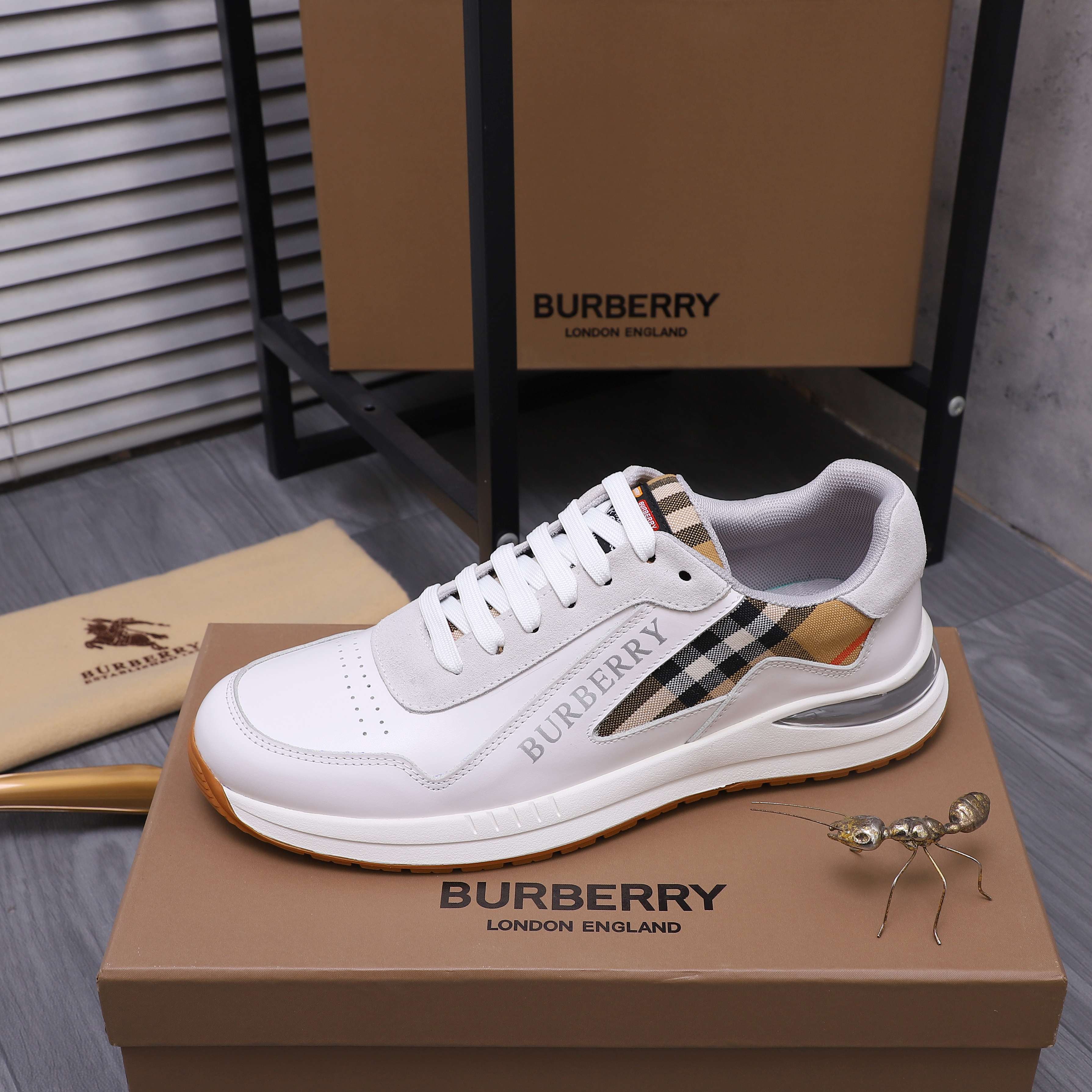 White Burberry low-top sneakers with plaid side stripe and gum rubber sole
