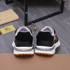 Pair of luxury sneakers from the back: black uppers with white soles and gum edging
