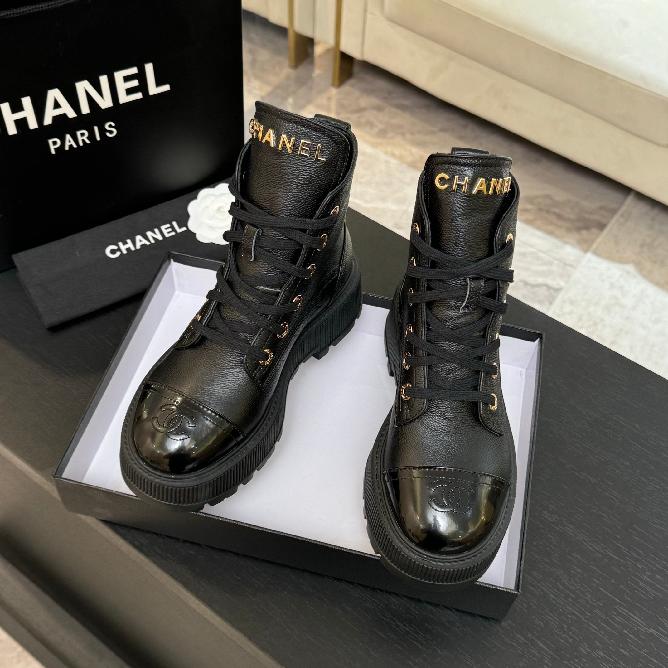 Black leather lace-up ankle boots with round toe, Chanel logo, gold eyelets