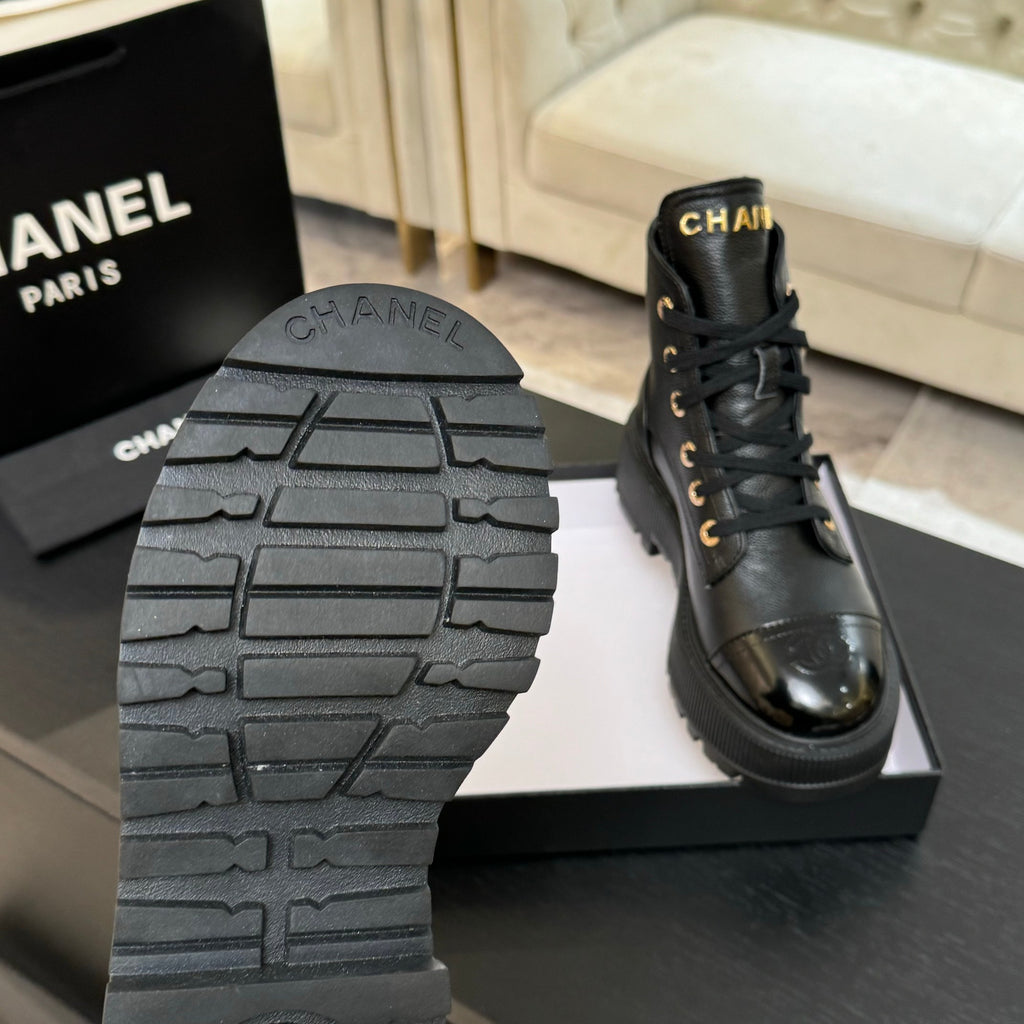 Black leather lace-up ankle boots; visible tread sole and gold lace eyelets