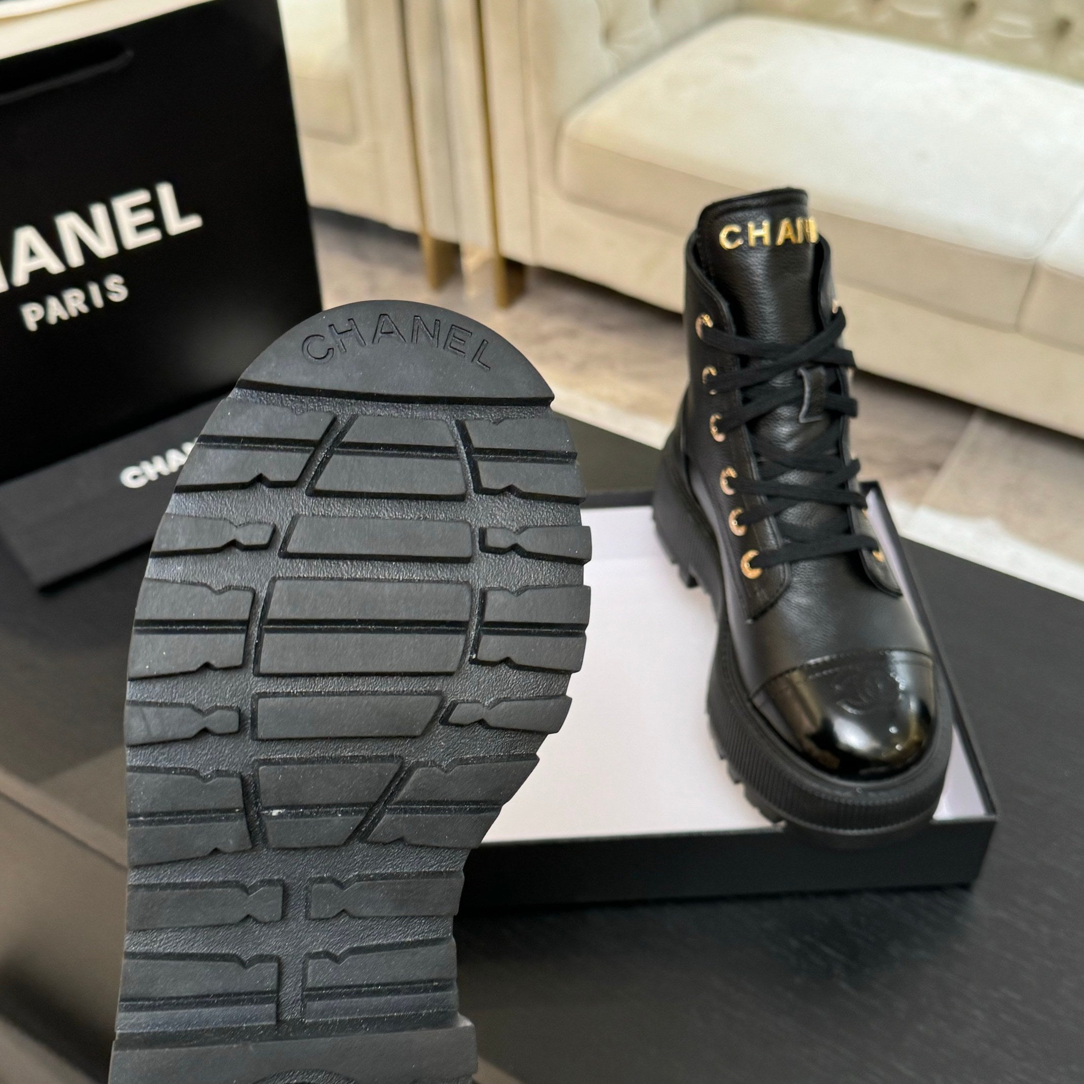 Black leather lace-up ankle boots; visible tread sole and gold lace eyelets