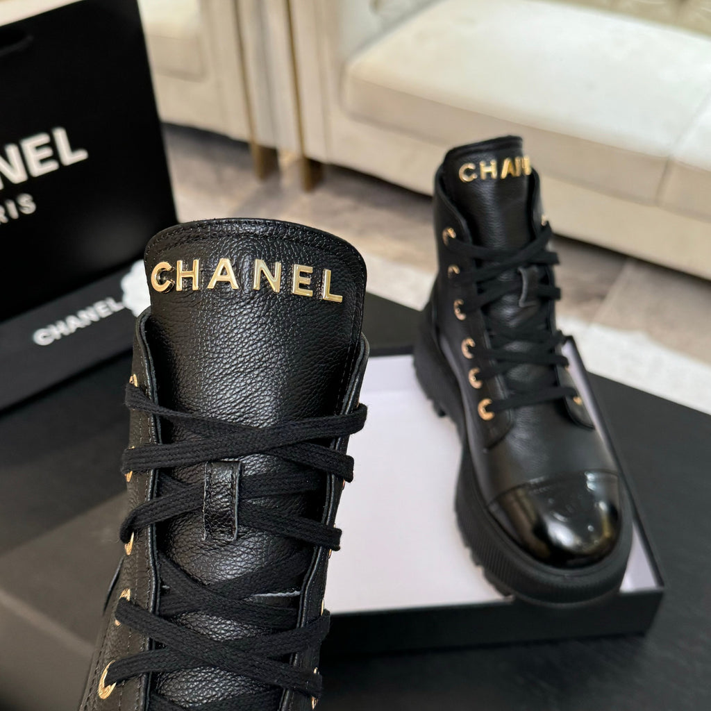 Black leather high-top ankle boots with Chanel logo and gold lace eyelets