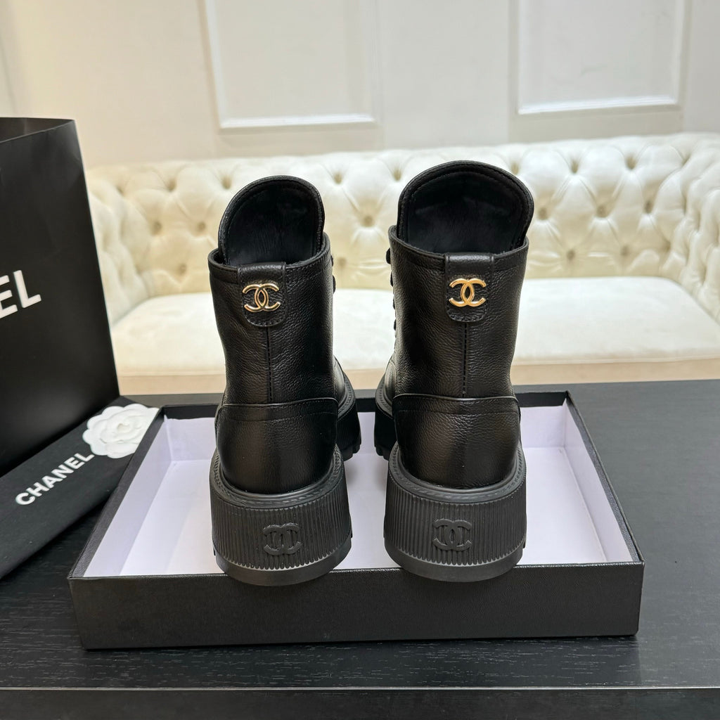 Black leather ankle boots with Chanel logo on heel and gold-toned emblem