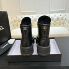Black leather ankle boots with Chanel logo on heel and gold-toned emblem