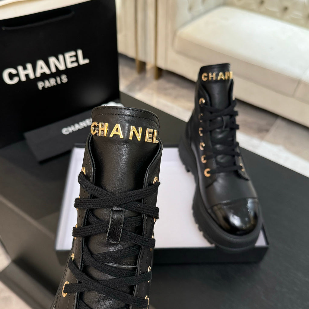 Chanel black leather lace-up ankle boot pair with logo tabs at collars