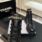 Chanel black leather lace-up ankle boot pair with logo tabs at collars